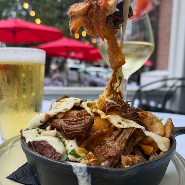 Under the Moon's New American poutine with braised short rib, cheese curds, and gravy, with beer and wine.